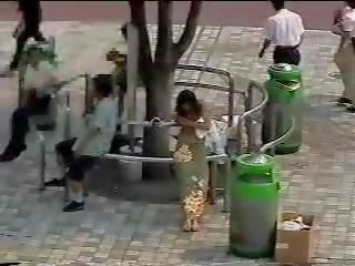 Skiftande i den gata - japanska ung flickvän i offentlig först delen