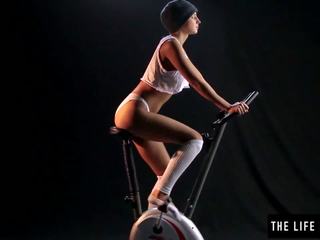 Burvīgas sweaty pusaudze slēgumu an exercise bike sēdeklis.